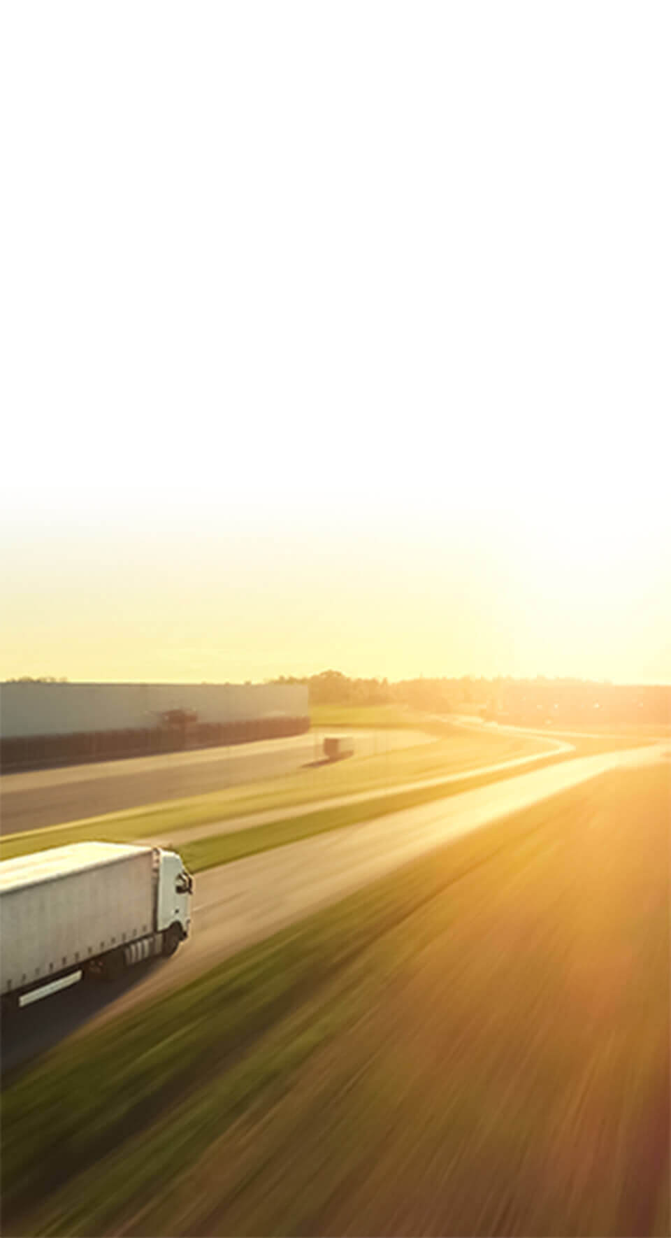 Semi truck driving on the highway towards the sunset